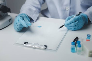 Laboratuvar asistanı, tıp bilimcisi, kimya araştırmacısı kimyasal test tüpünden cam bir tüp tutuyor, kimyasal deney yapıyor ve hastanın örneğini inceliyor. Tıp ve araştırma konsepti.