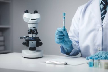 Laboratuvar asistanı, tıp bilimcisi, kimya araştırmacısı kimyasal test tüpünden cam bir tüp tutuyor, kimyasal deney yapıyor ve hastanın örneğini inceliyor. Tıp ve araştırma konsepti.