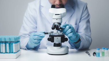 Laboratuvar asistanı, tıp bilimcisi, kimya araştırmacısı kimyasal test tüpünden cam bir tüp tutuyor, kimyasal deney yapıyor ve hastanın örneğini inceliyor. Tıp ve araştırma konsepti.