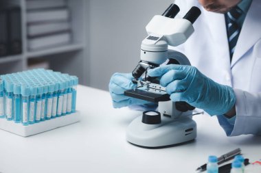 Laboratuvar asistanı, tıp bilimcisi, kimya araştırmacısı kimyasal test tüpünden cam bir tüp tutuyor, kimyasal deney yapıyor ve hastanın örneğini inceliyor. Tıp ve araştırma konsepti.