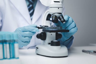 Laboratuvar asistanı, tıp bilimcisi, kimya araştırmacısı kimyasal test tüpünden cam bir tüp tutuyor, kimyasal deney yapıyor ve hastanın örneğini inceliyor. Tıp ve araştırma konsepti.