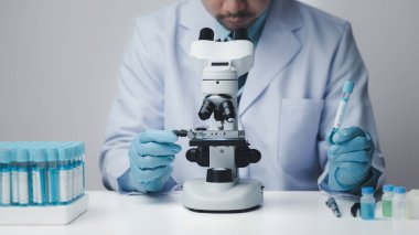 Laboratuvar asistanı, tıp bilimcisi, kimya araştırmacısı kimyasal test tüpünden cam bir tüp tutuyor, kimyasal deney yapıyor ve hastanın örneğini inceliyor. Tıp ve araştırma konsepti.