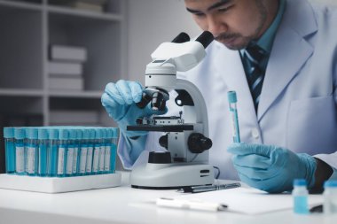 Laboratuvar asistanı, tıp bilimcisi, kimya araştırmacısı kimyasal test tüpünden cam bir tüp tutuyor, kimyasal deney yapıyor ve hastanın örneğini inceliyor. Tıp ve araştırma konsepti.