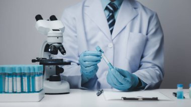 Laboratuvar asistanı, tıp bilimcisi, kimya araştırmacısı kimyasal test tüpünden cam bir tüp tutuyor, kimyasal deney yapıyor ve hastanın örneğini inceliyor. Tıp ve araştırma konsepti.
