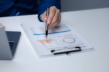 İşadamı şirketinde özel bir ofiste oturuyor ve şirketin mali belgelerini inceliyor, üst düzey yönetim finansal bilgilerin doğruluğunu kontrol ediyor. Mali yönetim.