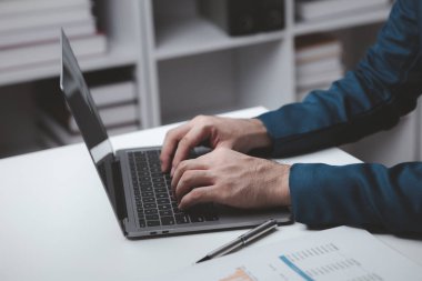 Laptop klavyesinde yazan kişi, dizüstü bilgisayarda çalışan iş adamı, iş arkadaşlarına mesaj yazıyor ve toplantıyı özetlemek için mali bilgi tablosu hazırlıyor..