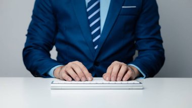 Bir bilgisayar klavyesinde yazan kişi, iş adamı bir şirkette çalışıyor, iş arkadaşlarına mesajlar yazıyor ve toplantıları özetliyor. Boşluğu kopyala.