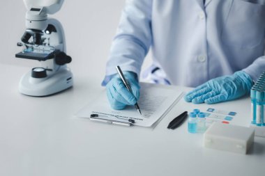 Laboratuvar asistanı, tıp bilimcisi, kimya araştırmacısı kimyasal test tüpünden cam bir tüp tutuyor, kimyasal deney yapıyor ve hastanın örneğini inceliyor. Tıp ve araştırma konsepti.