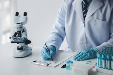 Laboratuvar asistanı, tıp bilimcisi, kimya araştırmacısı kimyasal test tüpünden cam bir tüp tutuyor, kimyasal deney yapıyor ve hastanın örneğini inceliyor. Tıp ve araştırma konsepti.
