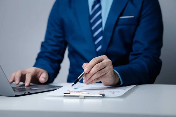 Businessman sits in a private office at his company and is reviewing company financial documents, senior management checking financial information for accuracy. Financial management.