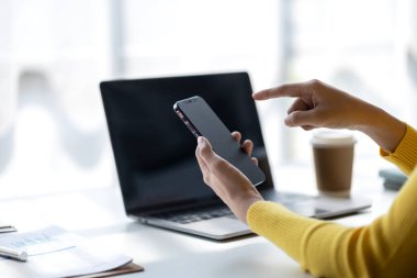 Genç bir kadın girişimci bir işkadınıdır, ofiste oturur ve cep telefonu kullanır, işlerini genç bir nesilden yönetir ve yönetir. Girişim işletme yönetimi kavramı.