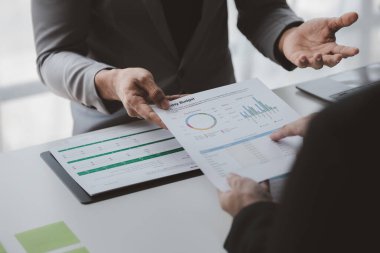 Yöneticiler ve yöneticiler bir konferans odasında toplanıyorlar, masanın üzerinde şirketin mali durumu hakkında bazı belgeler var, yöneticiler yönetim ile mali bilgileri tartışıyor..