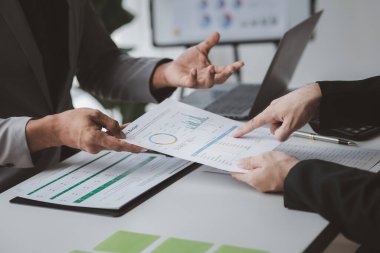 Yöneticiler ve yöneticiler bir konferans odasında toplanıyorlar, masanın üzerinde şirketin mali durumu hakkında bazı belgeler var, yöneticiler yönetim ile mali bilgileri tartışıyor..