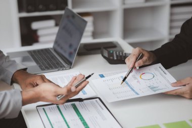 İki işadamı toplantı materyaline işaret ederek, ortak iş sorunlarını geliştirme ve çözme planında birlikte çalıştılar. Büyüme ve kalite için işletme yönetimi kavramı.