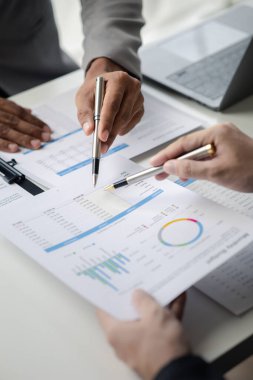 İki işadamı toplantı materyaline işaret ederek, ortak iş sorunlarını geliştirme ve çözme planında birlikte çalıştılar. Büyüme ve kalite için işletme yönetimi kavramı.