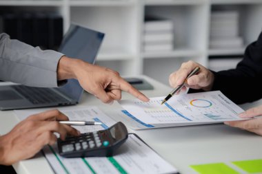 İki işadamı toplantı materyaline işaret ederek, ortak iş sorunlarını geliştirme ve çözme planında birlikte çalıştılar. Büyüme ve kalite için işletme yönetimi kavramı.