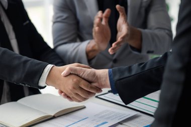 Business investor group holding hands, Two businessmen are agreeing on business together and shaking hands after a successful negotiation. Handshaking is a Western greeting or congratulation.