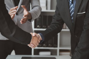 Business investor group holding hands, Two businessmen are agreeing on business together and shaking hands after a successful negotiation. Handshaking is a Western greeting or congratulation.