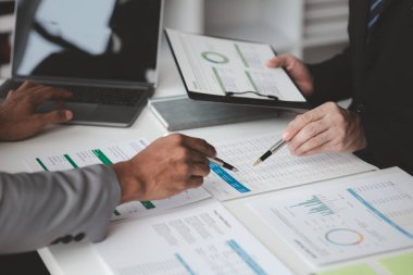 Yöneticiler ve yöneticiler bir konferans odasında toplanıyorlar, masanın üzerinde şirketin mali durumu hakkında bazı belgeler var, yöneticiler yönetim ile mali bilgileri tartışıyor..