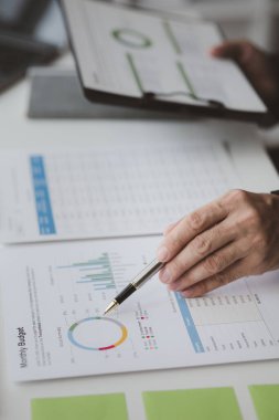 Yöneticiler ve yöneticiler bir konferans odasında toplanıyorlar, masanın üzerinde şirketin mali durumu hakkında bazı belgeler var, yöneticiler yönetim ile mali bilgileri tartışıyor..