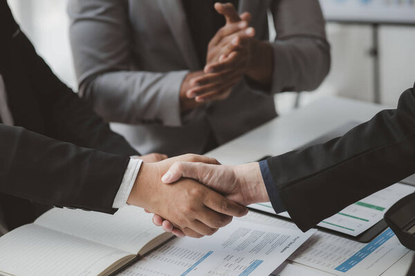 Business investor group holding hands, Two businessmen are agreeing on business together and shaking hands after a successful negotiation. Handshaking is a Western greeting or congratulation.