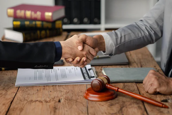 stock image Lawyers shake hands with clients who come to testify in the case of embezzlement from business partners who jointly invest in the business. The concept of hiring a lawyer for legal proceedings.