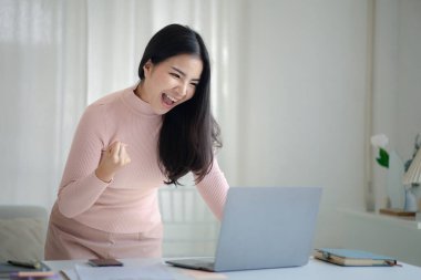 Genç bir kadın yeni başlayan bir iş kadınıdır, ofiste oturur ve mutlu görünür, işi genç nesilden yönetir ve yönetir. Girişim işletme yönetimi kavramı.