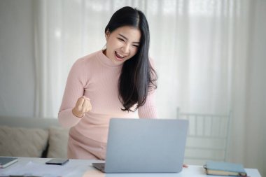 Genç bir kadın yeni başlayan bir iş kadınıdır, ofiste oturur ve mutlu görünür, işi genç nesilden yönetir ve yönetir. Girişim işletme yönetimi kavramı.