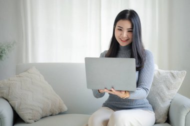 Kadın evdeki oturma odasındaki kanepede dizüstü bilgisayarda oynuyor, yoğun bir günün ardından hafta sonları dinleniyor, film izleyerek ve tabletinde müzik dinleyerek rahatlıyor. Tatil kavramı.