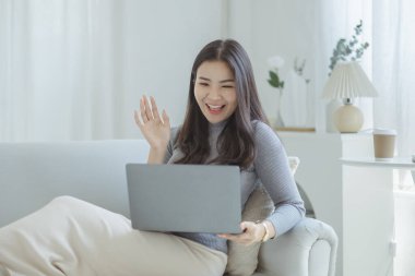 Kadın evdeki oturma odasındaki kanepede dizüstü bilgisayarda oynuyor, yoğun bir günün ardından hafta sonları dinleniyor, film izleyerek ve tabletinde müzik dinleyerek rahatlıyor. Tatil kavramı.