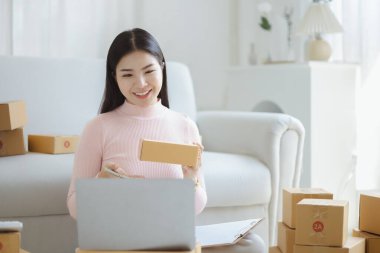 Çevrimiçi Satıcı, Genç Asyalı mağaza sahibi, çevrimiçi ürünler satarak geçiniyor, hedef kitleye ulaşmak için sosyal medya platformlarında canlı satış yapıyor. Çevrimiçi ürün satma kavramı.