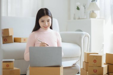 Çevrimiçi Satıcı, Genç Asyalı mağaza sahibi, çevrimiçi ürünler satarak geçiniyor, hedef kitleye ulaşmak için sosyal medya platformlarında canlı satış yapıyor. Çevrimiçi ürün satma kavramı.