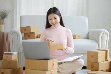 Çevrimiçi Satıcı, Genç Asyalı mağaza sahibi, çevrimiçi ürünler satarak geçiniyor, hedef kitleye ulaşmak için sosyal medya platformlarında canlı satış yapıyor. Çevrimiçi ürün satma kavramı.