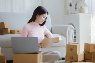 Çevrimiçi Satıcı, Genç Asyalı mağaza sahibi, çevrimiçi ürünler satarak geçiniyor, hedef kitleye ulaşmak için sosyal medya platformlarında canlı satış yapıyor. Çevrimiçi ürün satma kavramı.