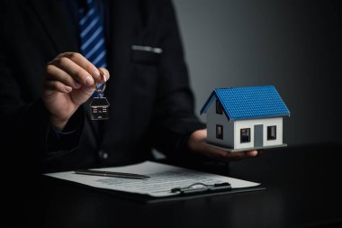 Ev satış temsilcileri ve satış temsilcileri projedeki evleri görmek isteyen müşterilere projede konut detaylarını tavsiye ediyorlar. Gayrimenkul ticareti.