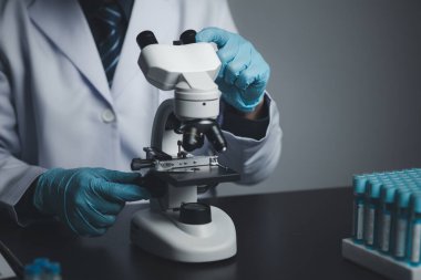 Laboratuvar asistanı, tıp bilimcisi, kimya araştırmacısı kimyasal test tüpünden cam bir tüp tutuyor, kimyasal deney yapıyor ve hastanın örneğini inceliyor. Tıp ve araştırma konsepti.