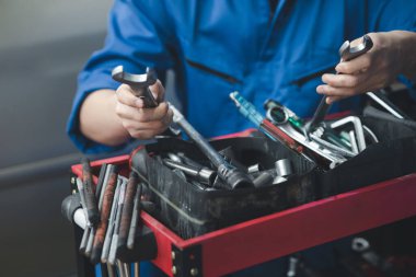 Araç raflarında otomobil tamir araçlarını arayan profesyonel araba tamircileri, her türlü otomobil uzmanları, uzman oto tamircileri ve akredite edilmiş otomobil tamir merkezleri.