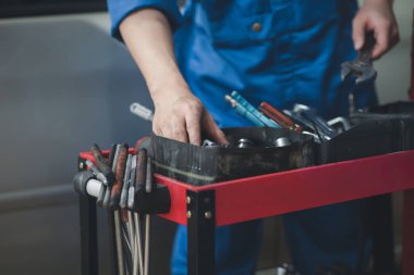 Araç raflarında otomobil tamir araçlarını arayan profesyonel araba tamircileri, her türlü otomobil uzmanları, uzman oto tamircileri ve akredite edilmiş otomobil tamir merkezleri.