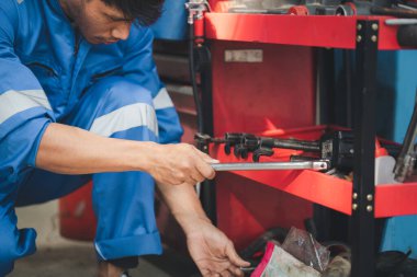 Araç raflarında otomobil tamir araçlarını arayan profesyonel araba tamircileri, her türlü otomobil uzmanları, uzman oto tamircileri ve akredite edilmiş otomobil tamir merkezleri.