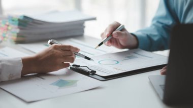 Businessman is reviewing monthly sales documents for analysis and marketing plans for more sales growth, they are the founders of young companies co-founding startups. Sales management concept.