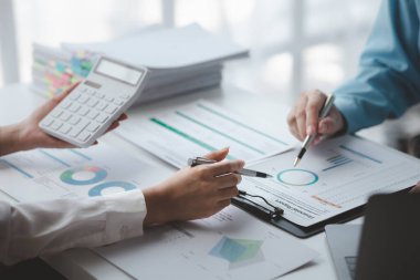 Businessman is reviewing monthly sales documents for analysis and marketing plans for more sales growth, they are the founders of young companies co-founding startups. Sales management concept.