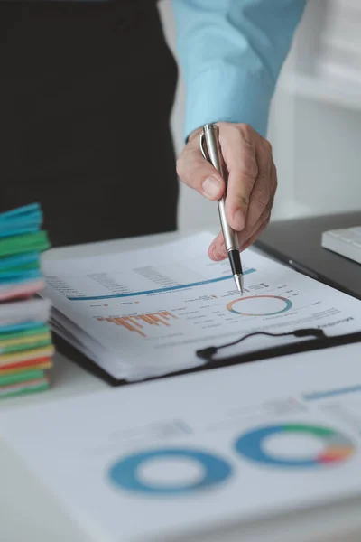 A business finance man is reviewing a company\'s financial documents prepared by the Finance Department for a meeting with business partners. Concept of validating the accuracy of financial numbers.