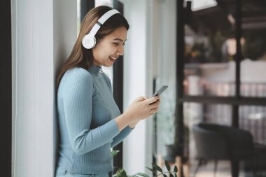 Cep telefonuyla oynayan bir kadın, akıllı telefonuyla internette sörf yapıyor ve arkadaşlarıyla sosyalleşiyor. Ve çevrimiçi platformlarda tanıdıklar. Cep telefonlarındaki sosyal uygulamalar kavramı.