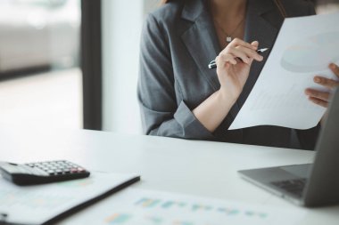 İşçi, işadamı belgelere bakıyor ve ofiste dizüstü bilgisayar kullanıyor. Girişim yönetimi, iş belgesi hazırlığı. Şirket içinde yönetim ve yönetim kavramları.