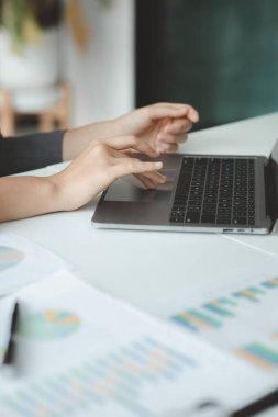 İşçi, işadamı belgelere bakıyor ve ofiste dizüstü bilgisayar kullanıyor. Girişim yönetimi, iş belgesi hazırlığı. Şirket içinde yönetim ve yönetim kavramları.