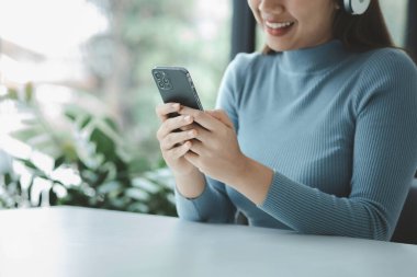 Cep telefonuyla oynayan bir kadın, akıllı telefonuyla internette sörf yapıyor ve arkadaşlarıyla sosyalleşiyor. Ve çevrimiçi platformlarda tanıdıklar. Cep telefonlarındaki sosyal uygulamalar kavramı.