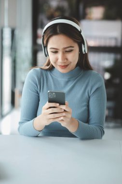 Cep telefonuyla oynayan bir kadın, akıllı telefonuyla internette sörf yapıyor ve arkadaşlarıyla sosyalleşiyor. Ve çevrimiçi platformlarda tanıdıklar. Cep telefonlarındaki sosyal uygulamalar kavramı.