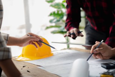 The home design architects are reviewing the house plan draft, the project commissioned by the client, and the custom design before delivery. Interior design and decoration ideas.