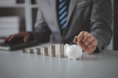 Person with pile of coins and piggy bank, money saving concept for future use and financial stability, salary management, personal finance, investment savings.