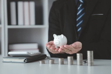 Person with pile of coins and piggy bank, money saving concept for future use and financial stability, salary management, personal finance, investment savings.